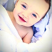 Aryez is registered to the contest to win money with this photo: baby, bed, blanket, blue_eyes, brown_hair, child, close_up, cozy, cute, face, happy, indoors, infant, lying_down, photography, portrait, smiling, soft_lighting, swaddled, white_blanket