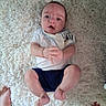 baby, infant, child, portrait, lying_down, rug, carpet, cream_colored, white_clothing, blue_shorts, hands, feet, wide_eyed, open_mouth, indoors, home, overhead_view, casual_photo, family, safe
