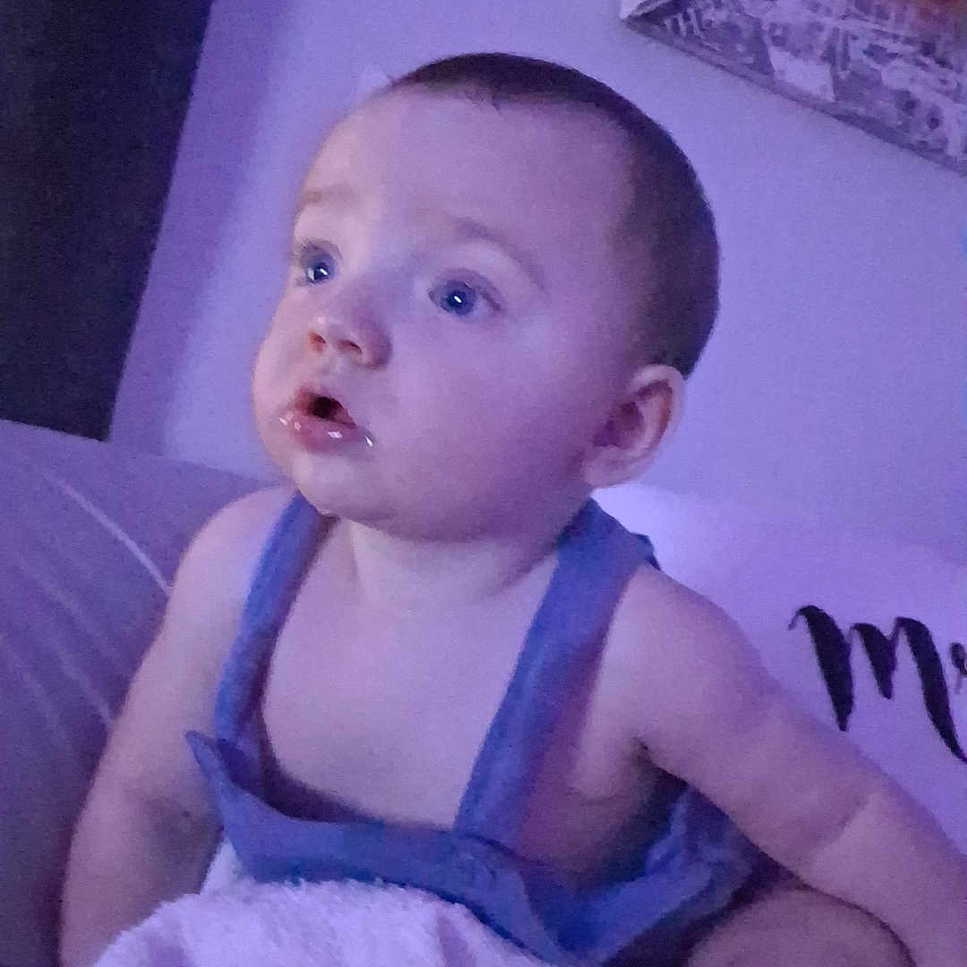 Aryez joined the competition — help win amazing prizes! baby, child, infant, sitting, blanket, bed, portrait, face, eyes, blue_eyes, short_hair, looking_away, indoor, bedroom, purple_lighting, clothing, overalls, candid, photography, home