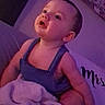 Aryez is registered to the contest to win money with this photo: baby, bare_arms, bed, blanket, child, clothing, cozy, curious, eyes, face, home, indoor, infant, nursery, open_mouth, overalls, photography, portrait, purple_lighting, sitting