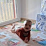 baby, child, smiling, play_mat, floor, window, natural_light, indoors, colorful, cartoon_characters, long_sleeve_shirt, diaper, crawling, happy, face, person, toy_box, puzzle_mat, home, young_child
