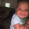 Khaleel is registered to the contest to win money with this photo: baby, being_held, bib, child, close_up, couch, eyes, face, family, happy, home, indoor, infant, living_room, portrait, scarf, sitting, smiling, white_shirt, window