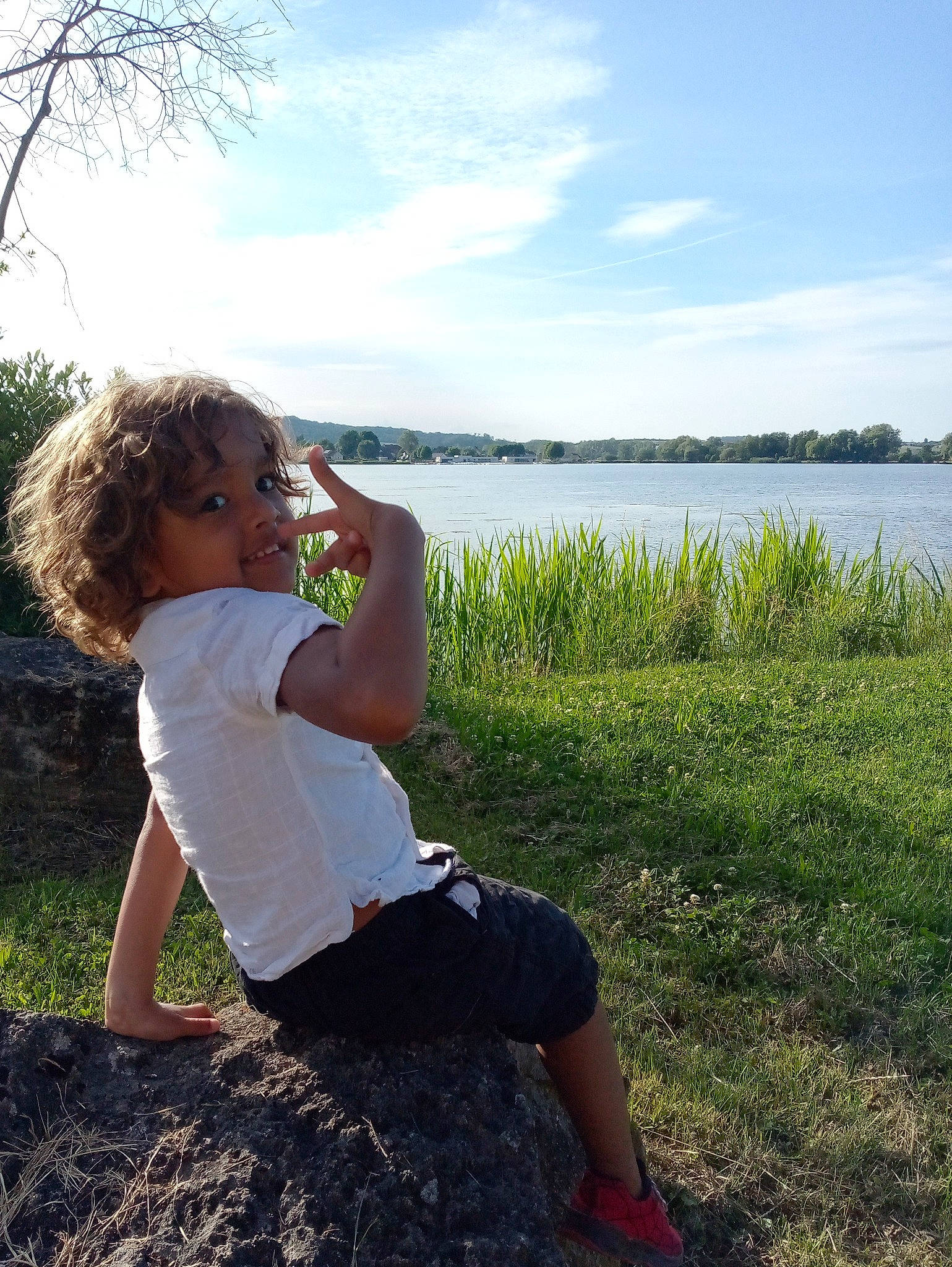 Imrane participe au concours pour gagner de l'argent avec cette photo : bank, cloud, flash_photography, grass, grass_family, grassland, happy, joy, knee, lake, leisure, meadow, natural_environment, nature, people_in_nature, person, plant, sky, summer, toddler