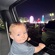 Westyn joined the competition — help win amazing prizes! toddler, child, car, night, carnival, ferris_wheel, lights, window, seatbelt, gray_shirt, blue_eyes, curly_hair, smile, hand, vehicle_interior, amusement_park, outdoor, fun, family, portrait