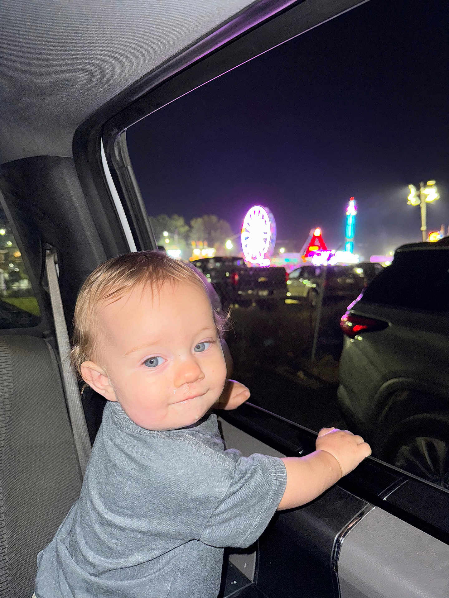 Westyn joined the competition — help win amazing prizes! toddler, child, car, night, carnival, ferris_wheel, lights, window, seatbelt, gray_shirt, blue_eyes, curly_hair, smile, hand, vehicle_interior, amusement_park, outdoor, fun, family, portrait