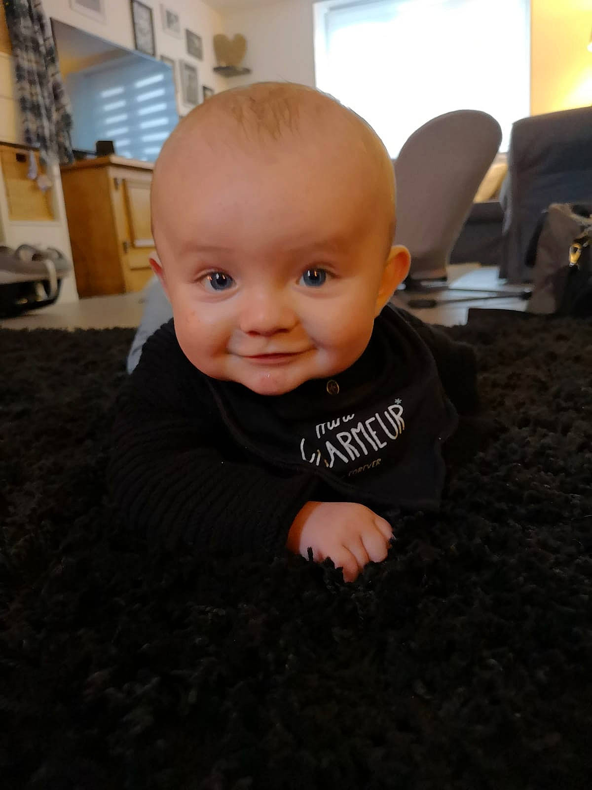 Léo participe au concours pour gagner de l'argent avec cette photo : baby, cheek, child, chin, crawling, eye, face, floor, flooring, head, person, sitting, skin, smile, toddler, wood