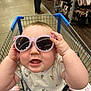 Clariece joined the competition — help win amazing prizes! baby, child, shopping_cart, sunglasses, purple_sunglasses, baby_bottle, blanket, grocery_store, aisle, person, clothing, toddler, cute, smiling, hand, face, head, retail, shopping, infant