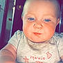 baby, child, blue_eyes, face, arm, shirt, indoor, door, light_gray, red_text, chubby_cheeks, closeup, person, young_child, portrait, cute, infant, looking_down, hand, expression