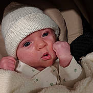 Thalia participe au concours pour gagner de l'argent avec cette photo : baby, blanket, child, closeup, clothing, cozy, cute, expression, face, fist, indoor, infant, knit_hat, newborn, person, portrait, rest, sleepwear, soft, warm