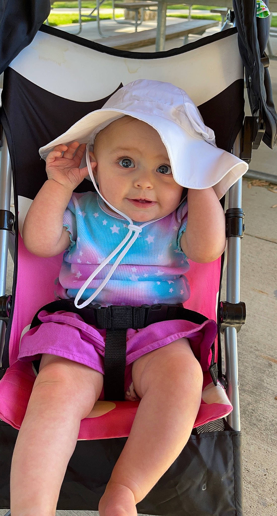 Hattie is registered to the contest to win money with this photo: baby, baby_carriage, baby_toddler_clothing, cheek, child, facial_expression, fun, happy, headwear, leg, magenta, mouth, person, pink, product, shorts, skin, smile, summer, thigh