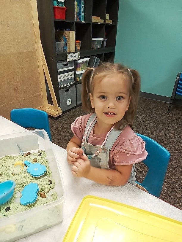 Kynlee is registered to the contest to win money with this photo: baby, baby_toddler_clothing, box, buttercream, chair, child, dessert, fun, icing, leisure, person, play, room, shelf, sitting, smile, t_shirt, table, tableware, toddler