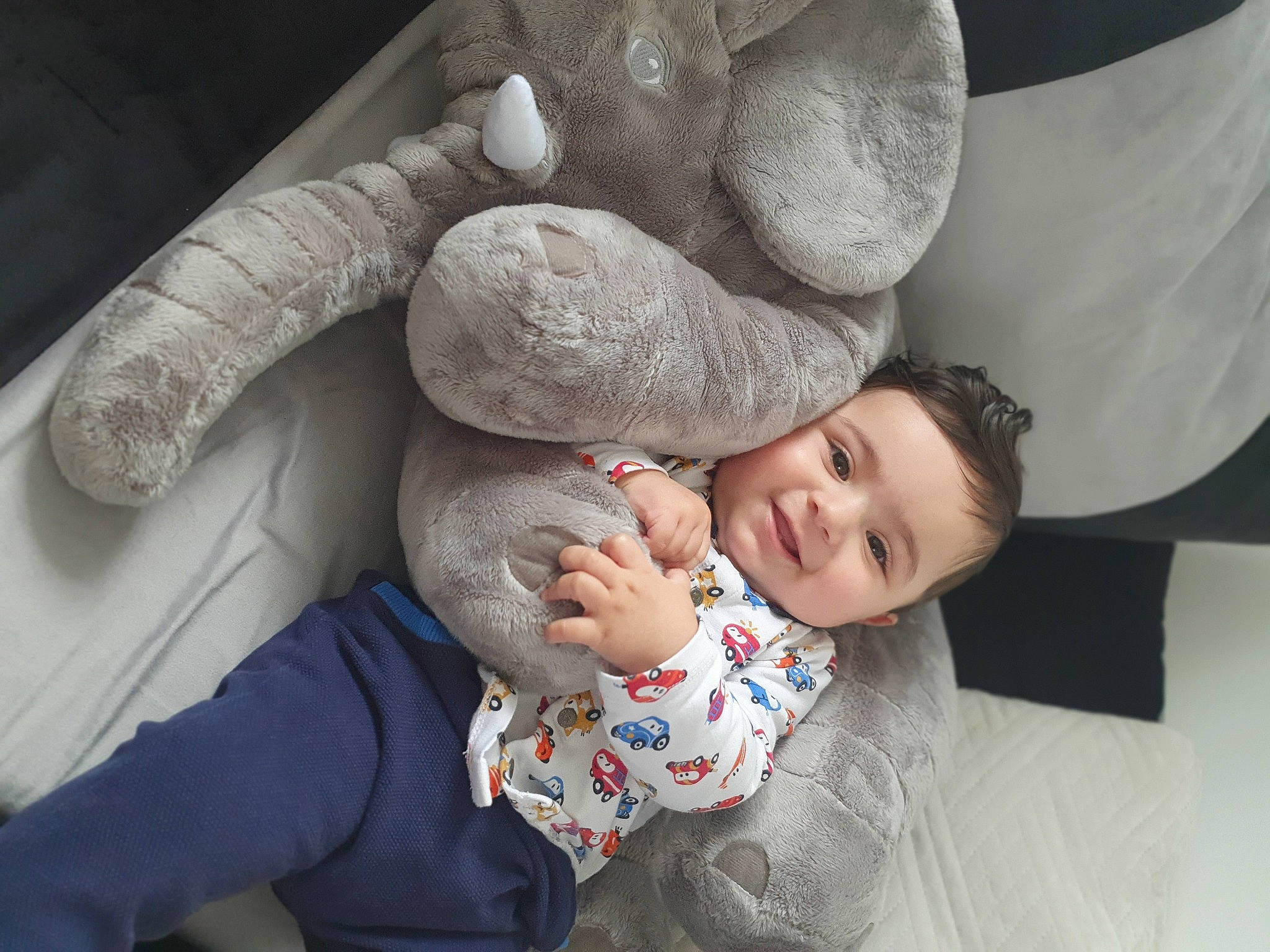 Sofiane a rejoint le concours — aidez-le/la à gagner de superbes lots ! baby, baby_toddler_clothing, child, comfort, couch, event, eye, facial_expression, fun, gesture, grey, happy, interaction, joy, nose, person, sitting, skin, smile, stuffed_toy