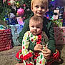 Amy is registered to the contest to win money with this photo: child, baby, sibling, christmas_tree, christmas_ornaments, christmas_lights, presents, pajamas, holiday_pajamas, carpet, indoors, portrait, smiling, festive, wrapped_gifts, ornament, sitting, holiday, young_child, family_moment