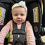 Amy is registered to the contest to win money with this photo: baby, infant, car_seat, headband, flower_headband, harness, safety_buckle, pink_clothing, blue_eyes, smiling, close_up, hands, green_toy, black_fabric, warning_label, seat_handle, portrait, cute, indoor, clothing