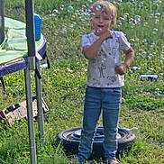 Xavier joined the competition — help win amazing prizes! child, barefoot, bubbles, grass, trampoline, tire, outdoor, play, joyful, clothing, nature, toy, field, sunlight, casual, person, greenery, summer, fun, young