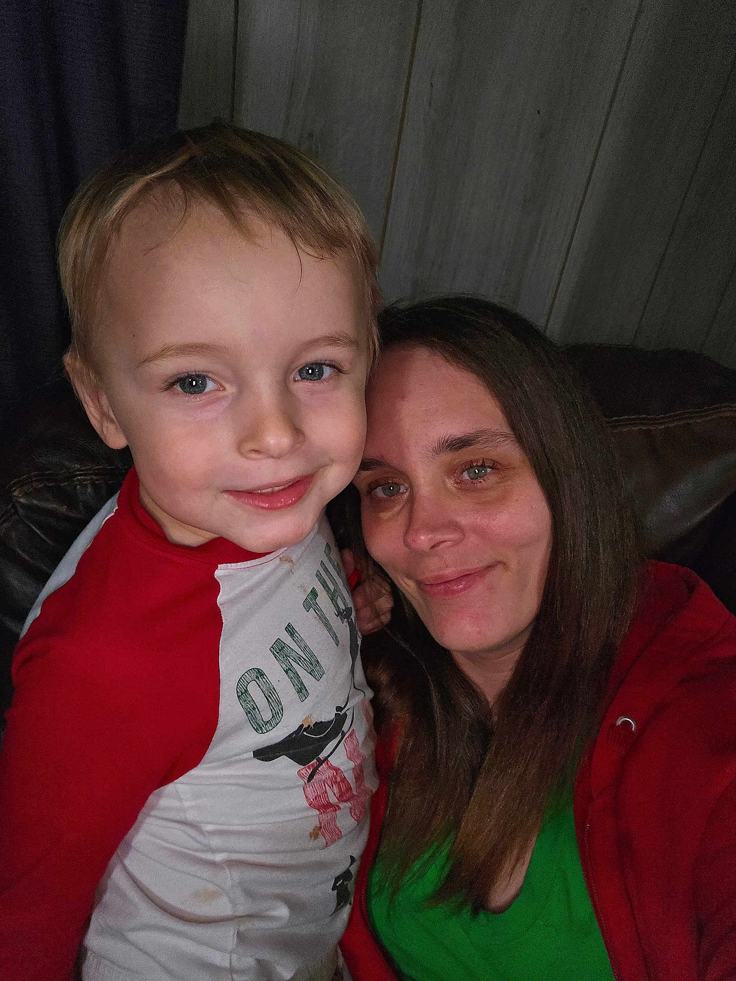 Xavier joined the competition — help win amazing prizes! child, woman, smile, portrait, indoor, couch, leather, long_hair, casual_clothing, red_shirt, green_shirt, face, happy, family, toddler, closeup, wooden_wall, home, person, sitting