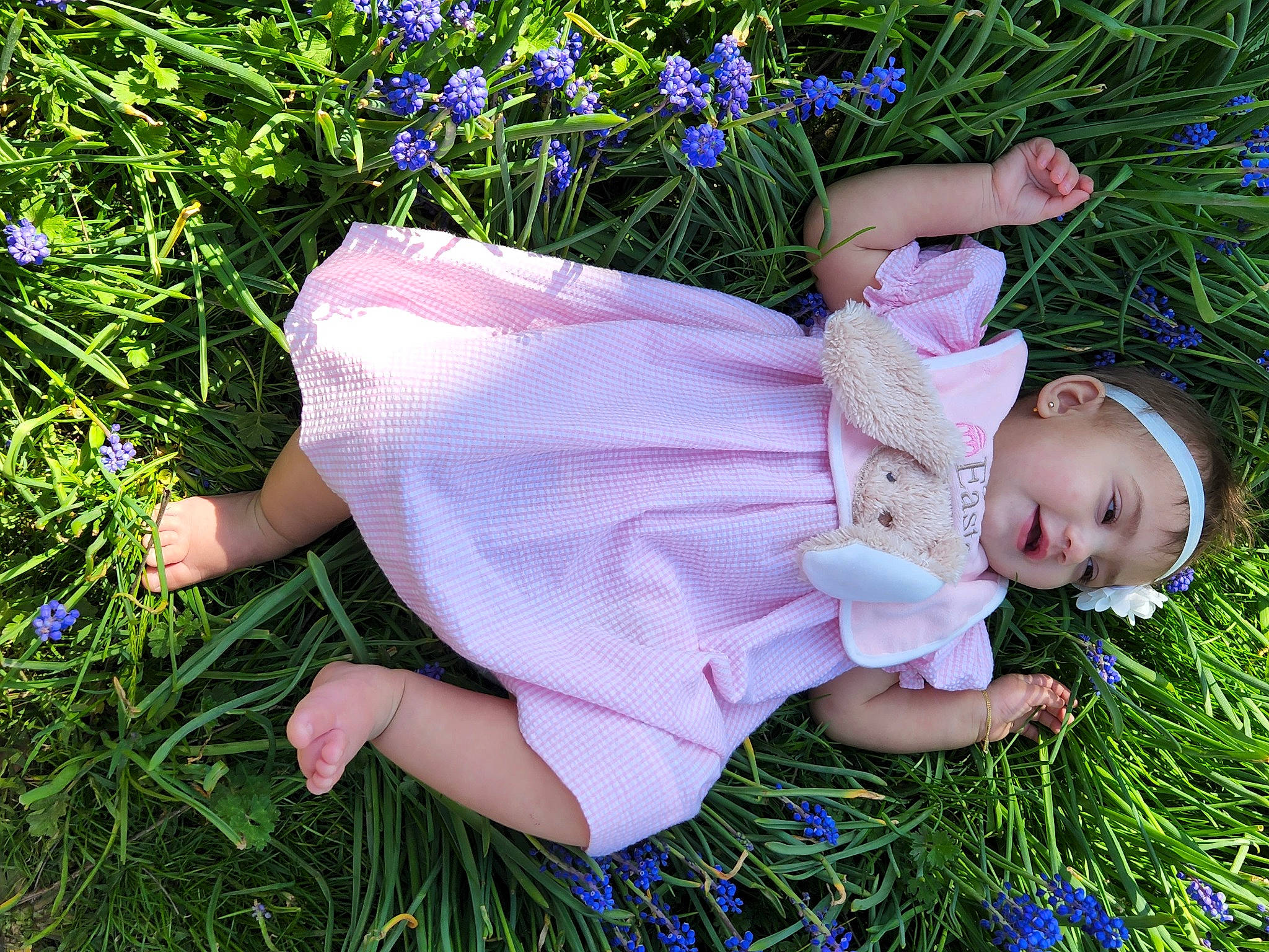 Freya is registered to the contest to win money with this photo: baby, baby_toddler_clothing, blue, botany, electric_blue, flower, grass, grass_family, grassland, green, groundcover, happy, hat, headwear, lawn, meadow, people_in_nature, person, plant, purple