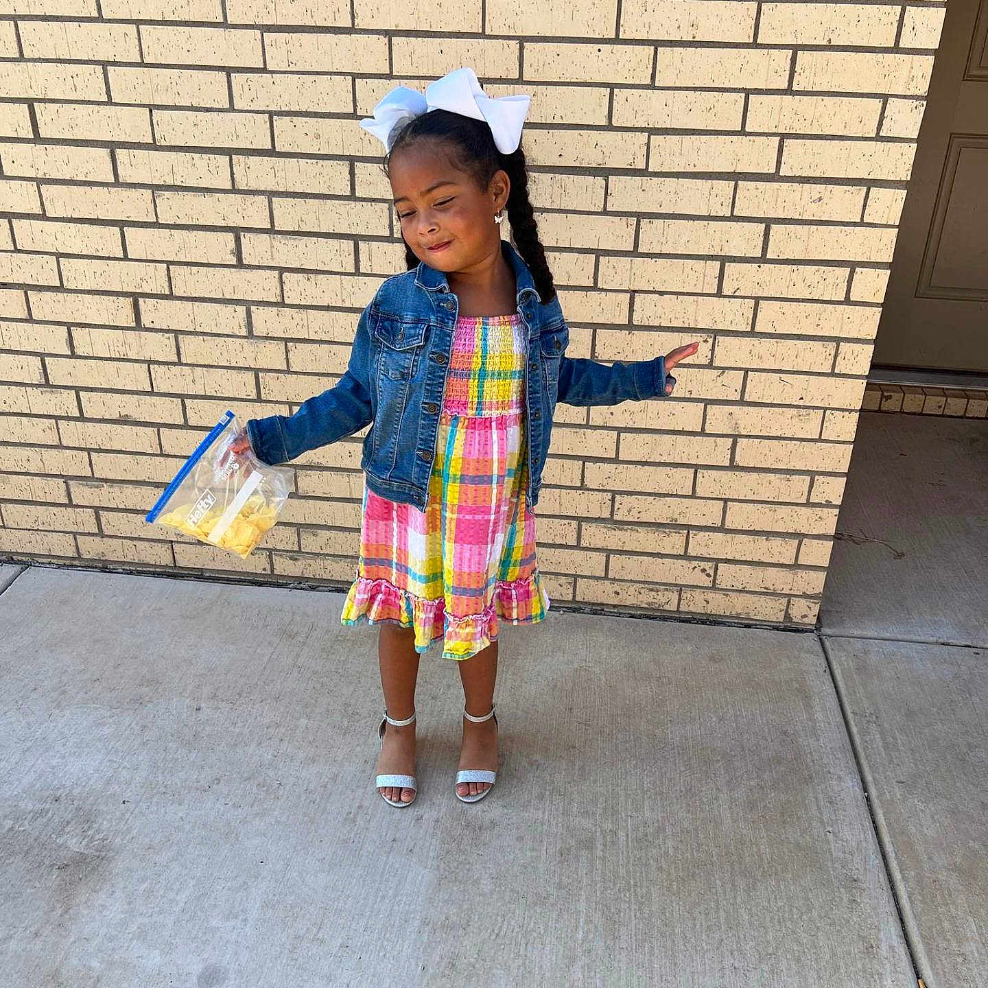 Loyalty is registered to the contest to win money with this photo: brick, child, city, clothing, face, female, footwear, girl, head, jeans, pants, person, photography, portrait, sandal, sitting, skirt, sleeve, standing, urban
