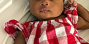Raine is registered to the contest to win money with this photo: arm, baby, bow, checkered_pattern, child, closeup, clothing, cute, drool, expressionless, face, headband, indoors, infant, lying_down, person, portrait, red_dress, skin, white_background