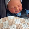 newborn, baby, sleeping, car_seat, hat, blanket, child, infant, clothing, seatbelt, portrait, closeup, peaceful, indoors, resting, cute, soft_light, person, baby_boy, safety