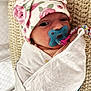 newborn, baby, pacifier, blanket, hat, floral_pattern, wrap, cushion, knitted, sleeping, infant, closeup, indoors, cozy, cute, person, child, face, resting, soft