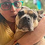 Lola Bean is registered to the contest to win money with this photo: person, dog, glasses, face, watch, arm, closeup, selfie, pet, fur, expression, brown, skin, outdoor, blurred_background, bokeh, casual, holding, portrait, watch_face