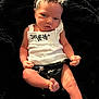 Kari is registered to the contest to win money with this photo: baby, black_clothing, blanket, cute, expression, floral_pattern, foot, hand, head, headband, indoors, infant, lying_down, newborn, person, portrait, skin, small, soft_texture, white_clothing