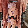 baby, child, stroller, pink, headband, bow, seatbelt, sitting, infant, cute, smile, indoors, clothing, person, face, legs, hands, fabric, metal, photography