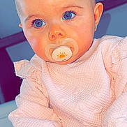 Zoony a rejoint le concours — aidez-le/la à gagner de superbes lots ! baby, child, pacifier, blue_eyes, pink_clothing, bow, indoor, portrait, cute, infant, sitting, young_child, face, hand, soft_texture, clothing, head_accessory, closeup, skin, human