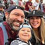 Charlie joined the competition — help win amazing prizes! family, selfie, man, woman, baby, smiling, hat, baseball_cap, beard, piercing, stadium, bleachers, crowd, outdoor, railings, jacket, striped_shirt, sunglasses, backpack, portrait