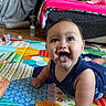 Caleb joined the competition — help win amazing prizes! baby, child, play_mat, tongue_out, smiling, indoor, floor, toy_blocks, colorful, happy, cute, crawling, person, face, clothing, home, furniture, blanket, infant, bright