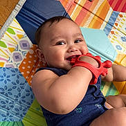 Caleb joined the competition — help win amazing prizes! baby, child, teething_toy, red, blue_clothing, play_mat, colorful, smile, happy, chewing, infant, indoor, skin, face, arm, hand, floor, wooden_floor, cute, young