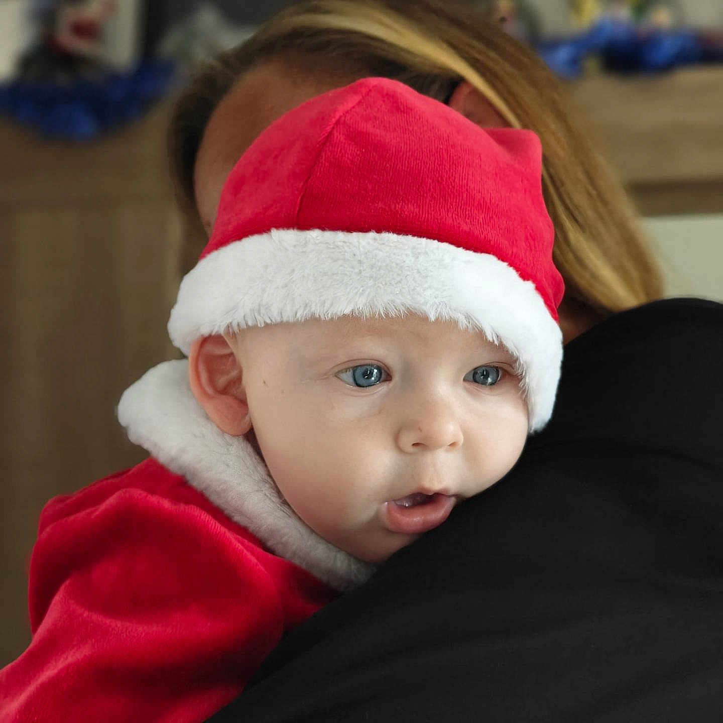 Maxence participe au concours pour gagner de l'argent avec cette photo : baby, blond_hair, blue_eyes, child, closeup, cute, embrace, expression, face, festive, holding, holiday, indoor, person, portrait, red_clothing, santa_hat, soft_light, warm, white_fur_trim
