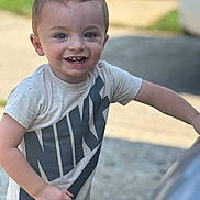 Junior joined the competition — help win amazing prizes! toddler, child, smiling, happy, nike, tshirt, short_sleeve, outdoor, daylight, hairstyle, mohawk, person, young_child, reaching, face, skin, casual_clothing, blurred_background, concrete, grass