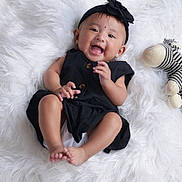 Zanaya joined the competition — help win amazing prizes! adorable, baby, black_dress, child, cute, earrings, feet, hands, happy, headband, indoor, infant, knitted_zebra, lying_down, playful, portrait, smile, soft_texture, toy, white_fur