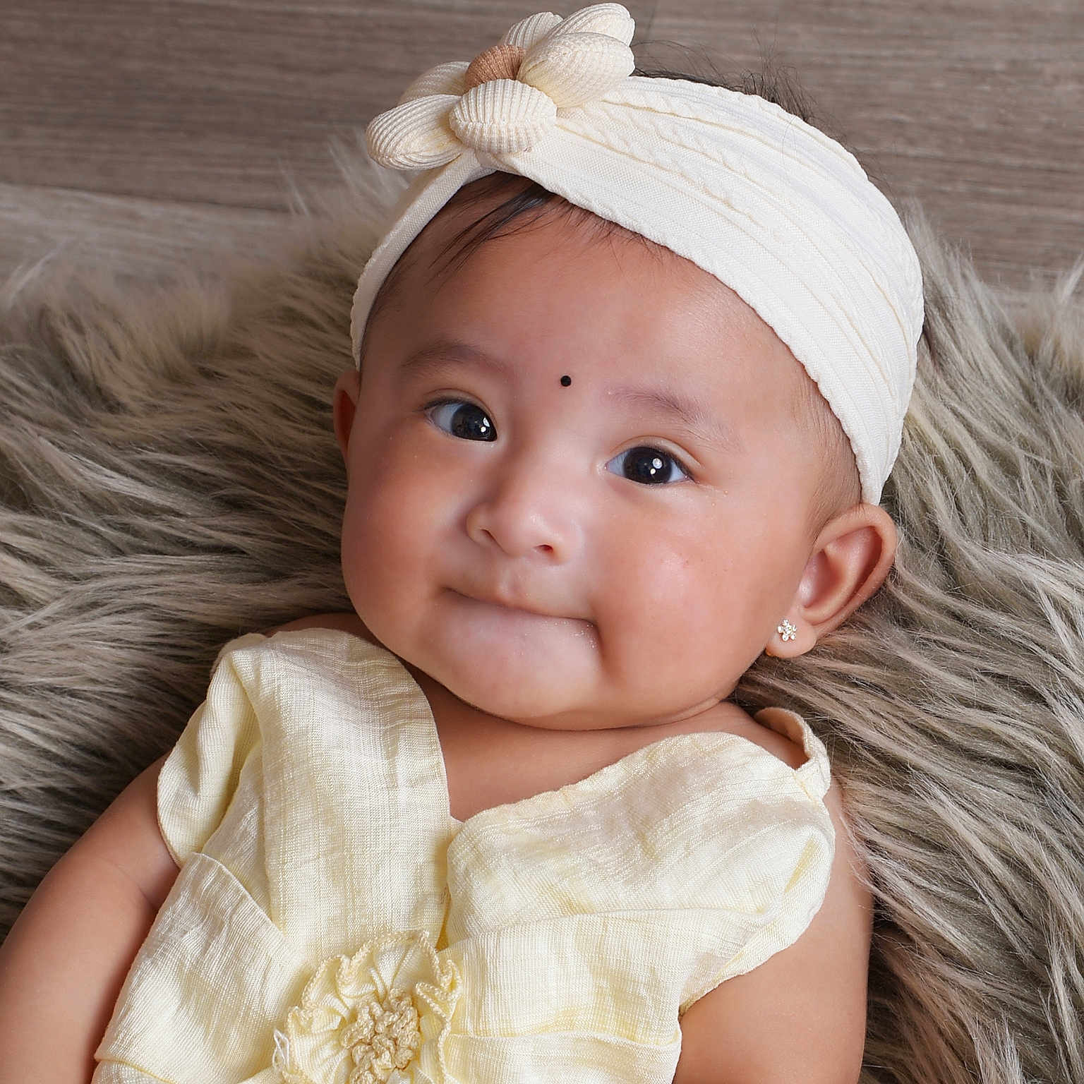 Zanaya is registered to the contest to win money with this photo: adorable, baby, child, closeup, cute, earrings, expression, fashion, flower, fluffy_rug, happy, headband, indoors, infant, person, portrait, skin, smile, soft_lighting, yellow_clothing