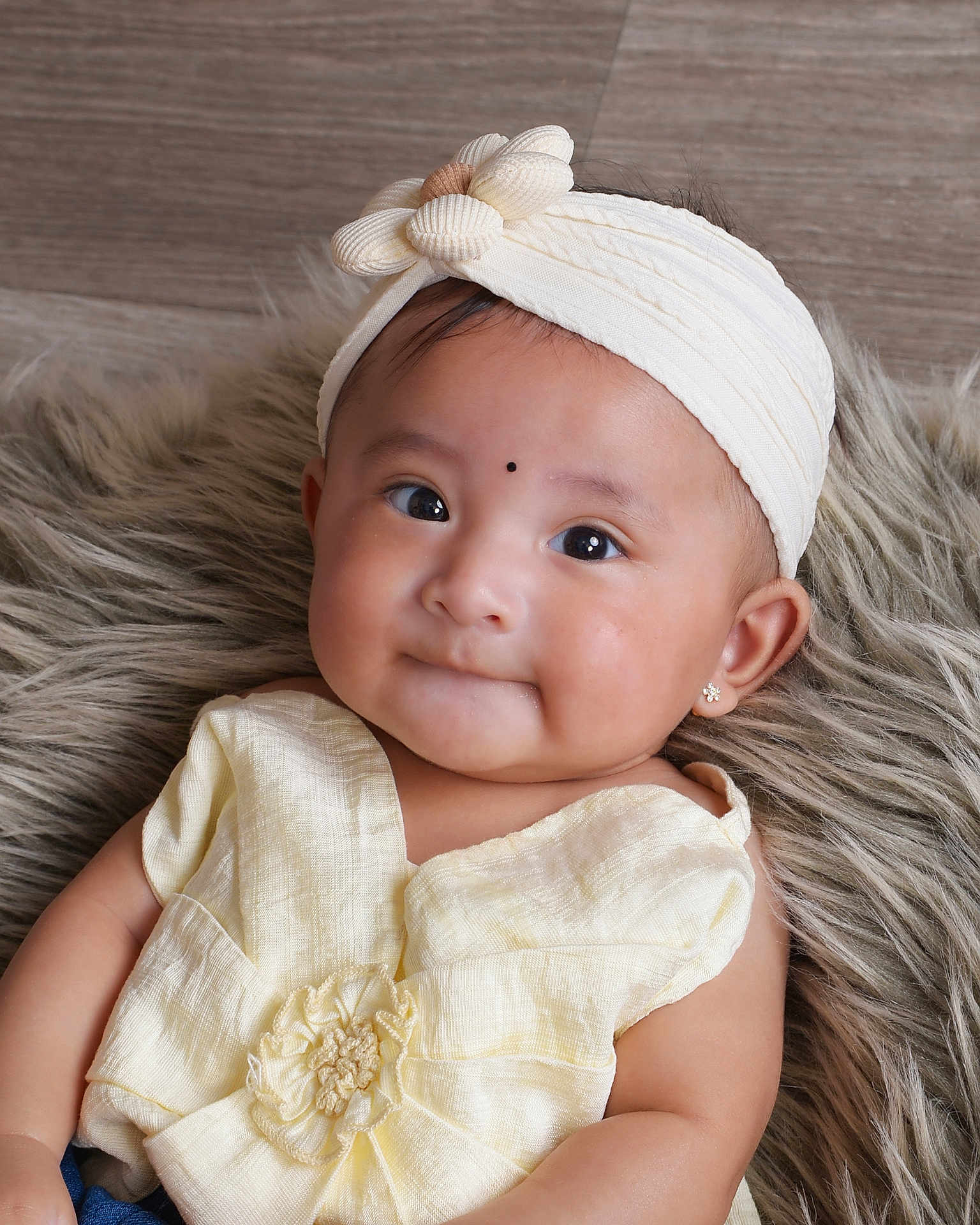 Zanaya is registered to the contest to win money with this photo: baby, child, headband, flower, yellow_clothing, earrings, fluffy_rug, portrait, cute, infant, smile, indoors, soft_lighting, closeup, expression, happy, skin, person, fashion, adorable