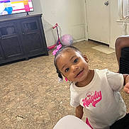 Nyarrie joined the competition — help win amazing prizes! toddler, child, smile, pink_bow, white_shirt, indoor, living_room, television, cabinet, floor, toy_scooter, ball, door, window, curtain, earrings, person, playful, happy, casual_clothing