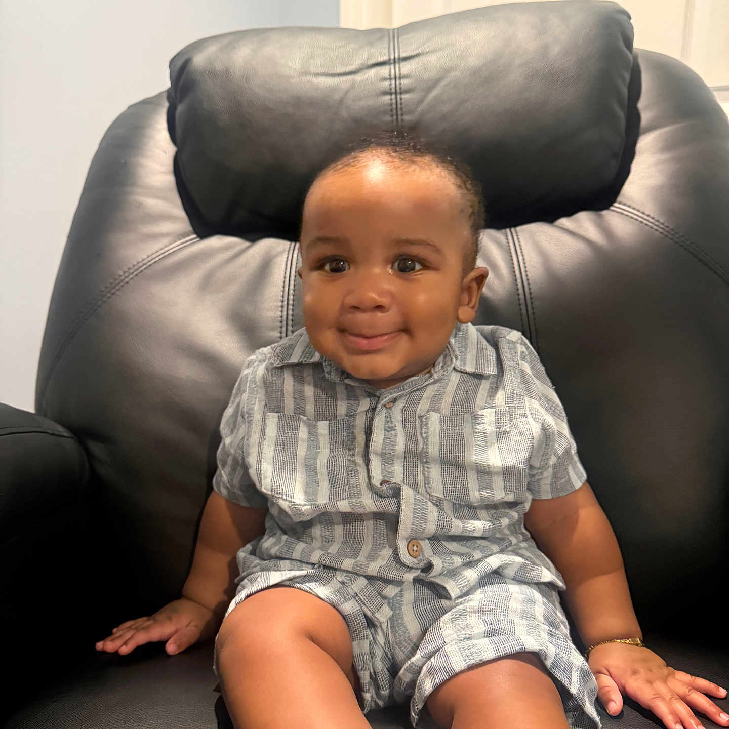 Synceir is registered to the contest to win money with this photo: toddler, child, smile, striped_clothing, shirt, shorts, sitting, leather_chair, black_chair, happy, indoor, person, baby, cute, young_child, casual_clothing, footwear, white_socks, portrait, home