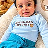 baby, baby_clothing, blanket, blue_clothing, chair, child, cozy, cushion, face, houseplant, indoors, infant, long_sleeves, nursery, pants, portrait, sitting, smiling, stuffed_animal, teddy_bear