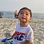 Adan joined the competition — help win amazing prizes! beach, beachwear, boy, child, clothing, coast, face, head, male, nature, outdoors, person, photography, portrait, sea, shoreline, sitting, summer, t_shirt, water