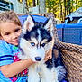 Nico is registered to the contest to win money with this photo: child, dog, puppy, siberian_husky, blue_eyes, wicker_chair, outdoor, trees, sunlight, nature, hugging, cute, pet, smiling, casual_clothing, cushion, furniture, summer, relaxing, family