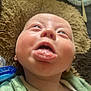 Frederick is registered to the contest to win money with this photo: baby, infant, tongue, face, expression, green_clothing, hand, lying_down, blanket, pacifier, plate, fork, food_remnants, texture, closeup, playful, skin, mouth, eyes, head