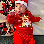 Simon participe au concours pour gagner de l'argent avec cette photo : baby, infant, christmas, holiday, festive_clothing, red_outfit, santa_hat, reindeer_sweater, couch, cushion, indoor, portrait, cute, smiling, child, person, holiday_decor, seasonal, cozy, happy