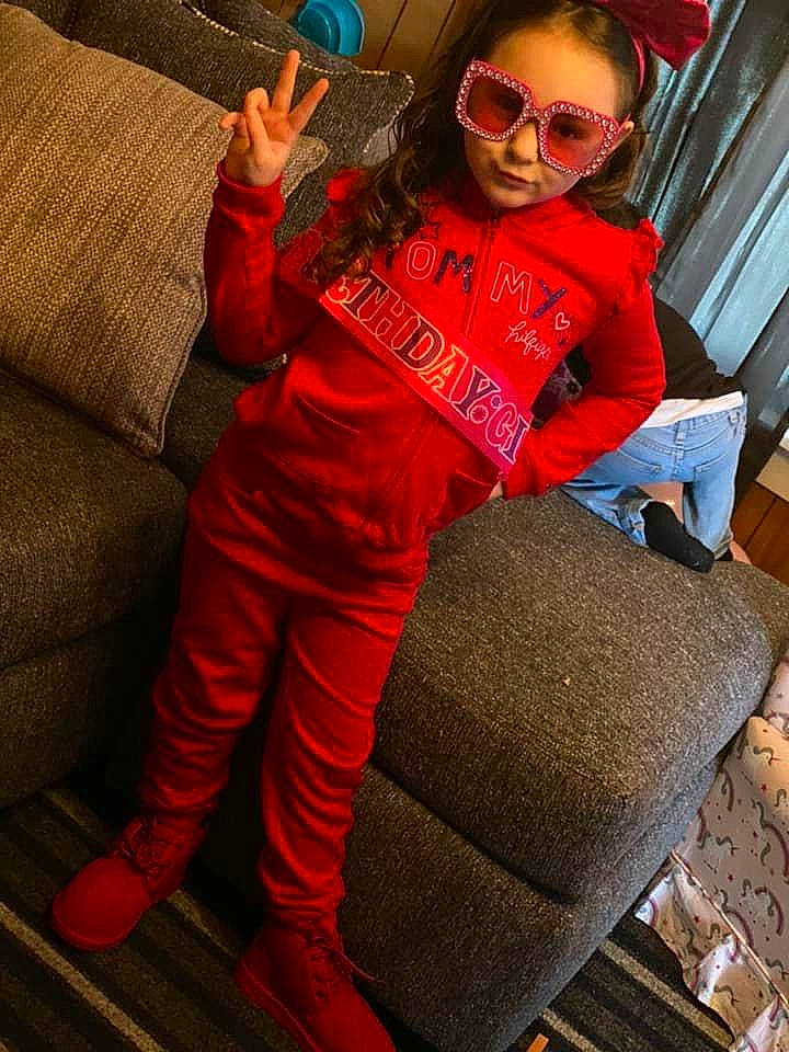 Arayah is registered to the contest to win money with this photo: bag, comfort, couch, eyewear, face, facial_expression, glasses, goggles, happy, knee, leg, luggage_and_bags, person, red, sleeve, sportswear, sunglasses, textile, thigh, vision_care