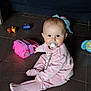baby, pacifier, pink_outfit, toy_car, floor, tiles, child, indoor, cute, smiling, play, toy, sitting, infant, person, young_child, colorful, fun, beads, comfort