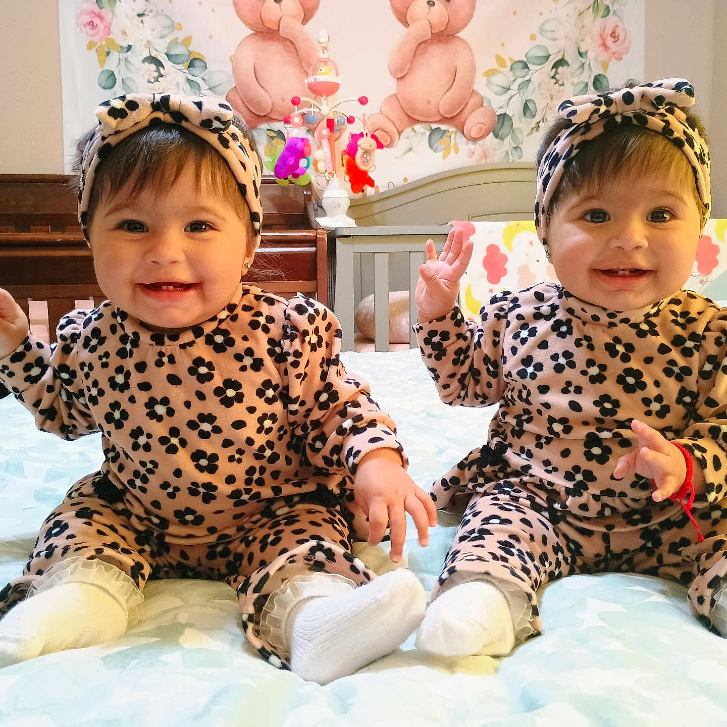 Lyanna And Leslie joined the competition — help win amazing prizes! baby, baby_mobile, bed, bedding, crib, cute, decorative_wall, hands_up, happy, headband, indoor, leopard_print, matching_outfits, nursery, portrait, sitting, smiling, socks, teddy_bear_wall, twins