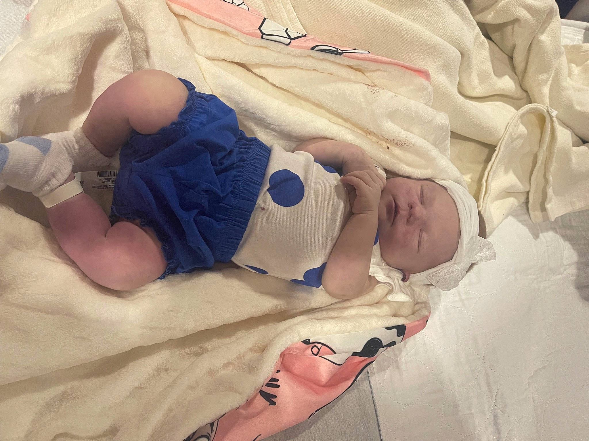 Olivia is registered to the contest to win money with this photo: abdomen, baby, baby_products, baby_toddler_clothing, chest, child, comfort, elbow, finger, hat, human_body, human_leg, knee, leg, linens, person, room, stomach, thigh, toddler