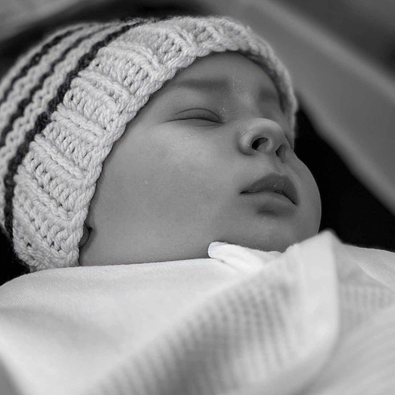 Naia is registered to the contest to win money with this photo: baby, black_and_white, blanket, calm, child, close_up, cozy, cute, face, hat, indoors, infant, knitted_hat, newborn, peaceful, portrait, resting, sleeping, soft_texture, wrapped