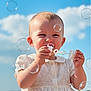 baby, child, bubbles, white_dress, outdoor, blue_sky, clouds, playing, happy, portrait, summer, cute, sunlight, nature, grass, innocence, smiling, fun, closeup, young_child